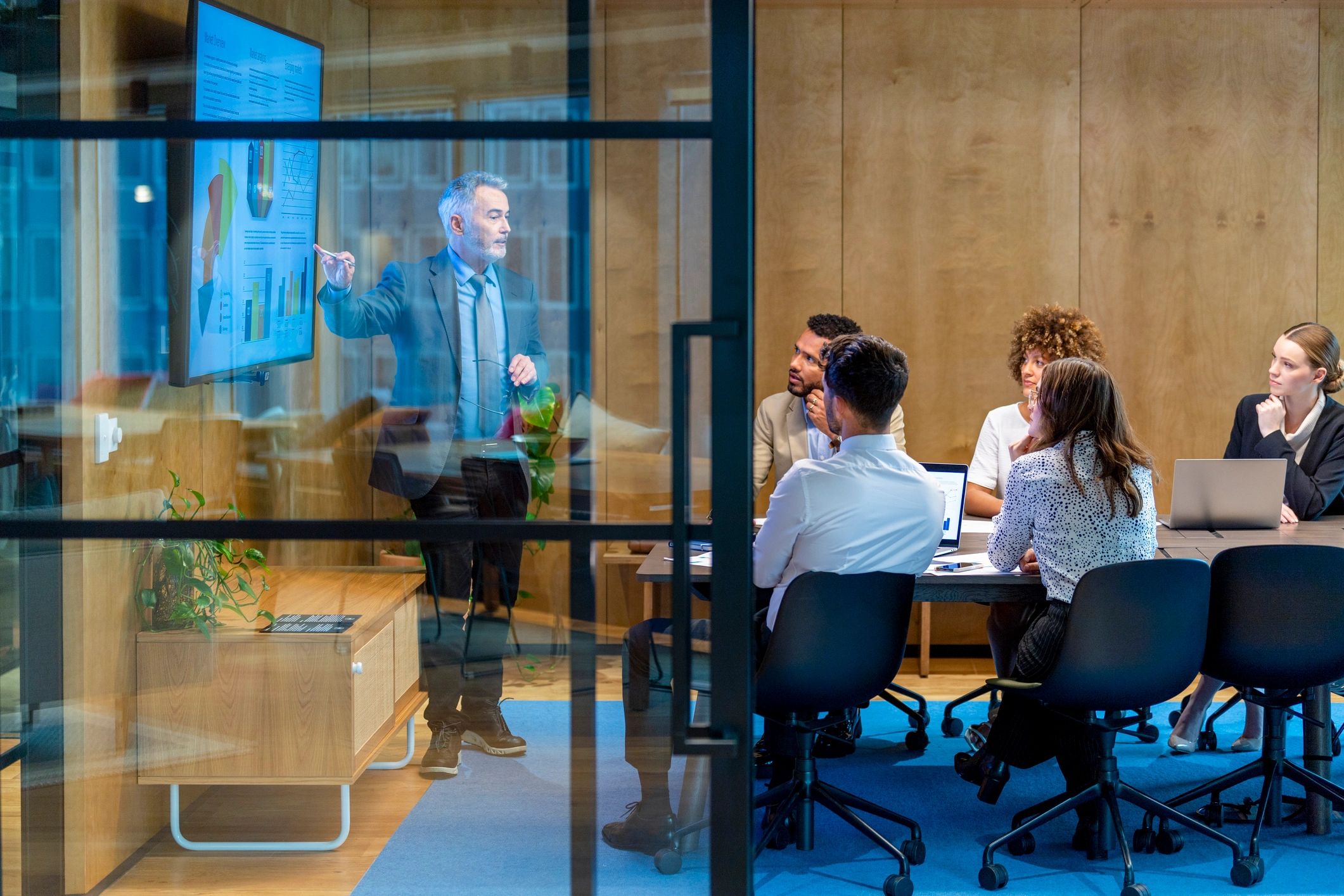Executive presenting data and charts in a boardroom